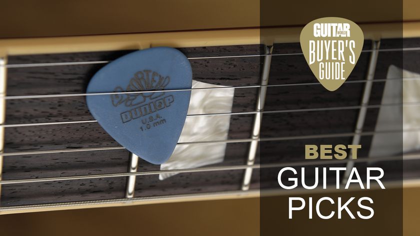 A Dunlop Tortex guitar pick nestled between the strings of an electric guitar