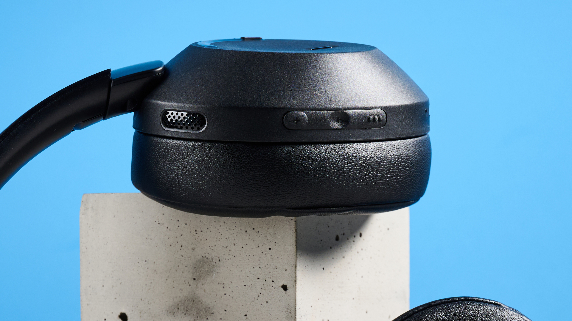 the mixx streamq c4 headphones in black with a blue background showing the soft cups and buttons controls