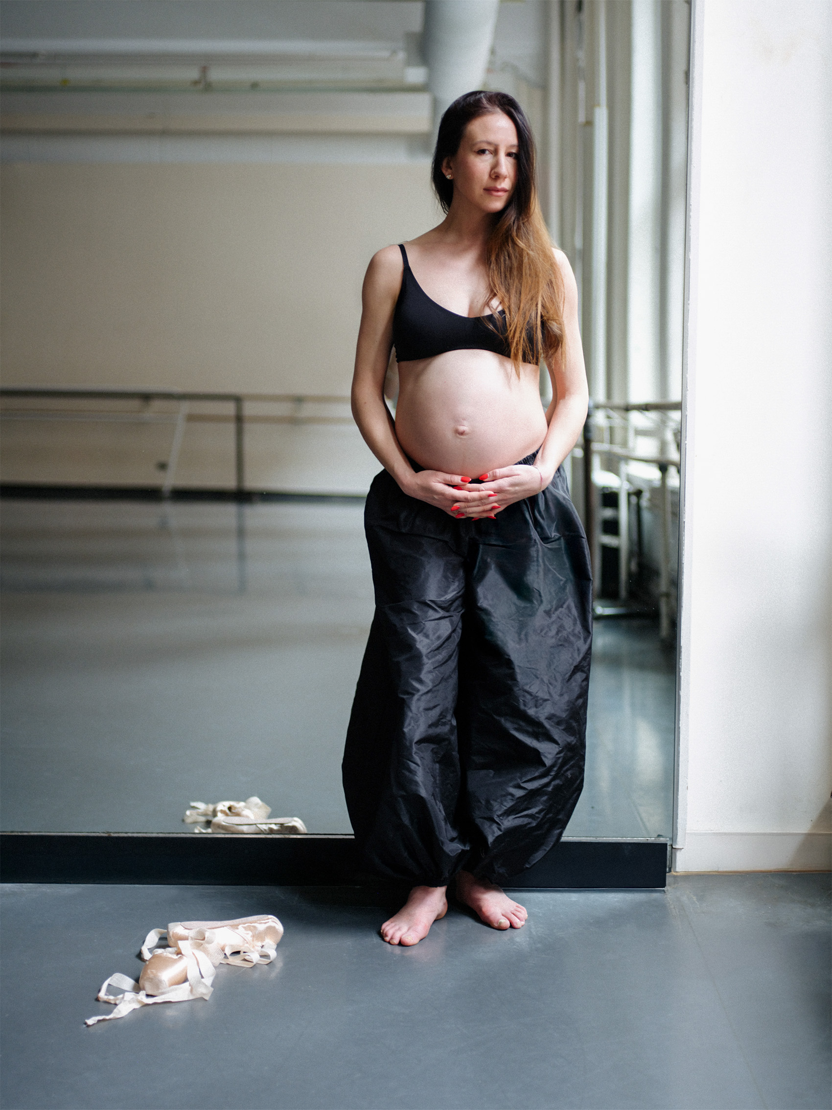 Isabella Boylston stands barefoot in a ballet studio with pointe shoes on the floor.