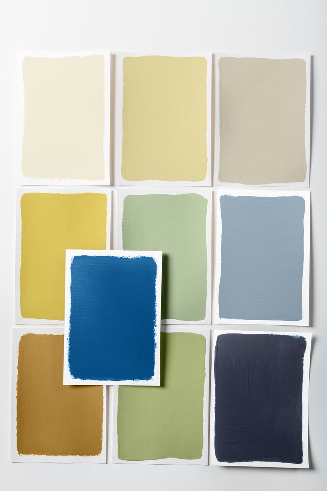 Image of nine color swatches of a palette in neutral, yellows, and greens that support a bright blue paint color.