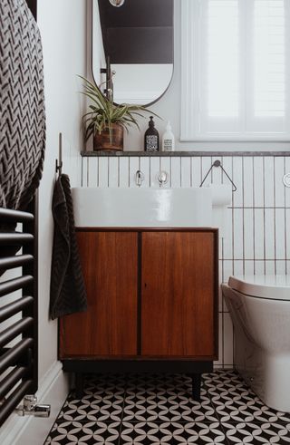 a bathroom with upcycled cabinet as bathroom storage with retro floor and wall tiles