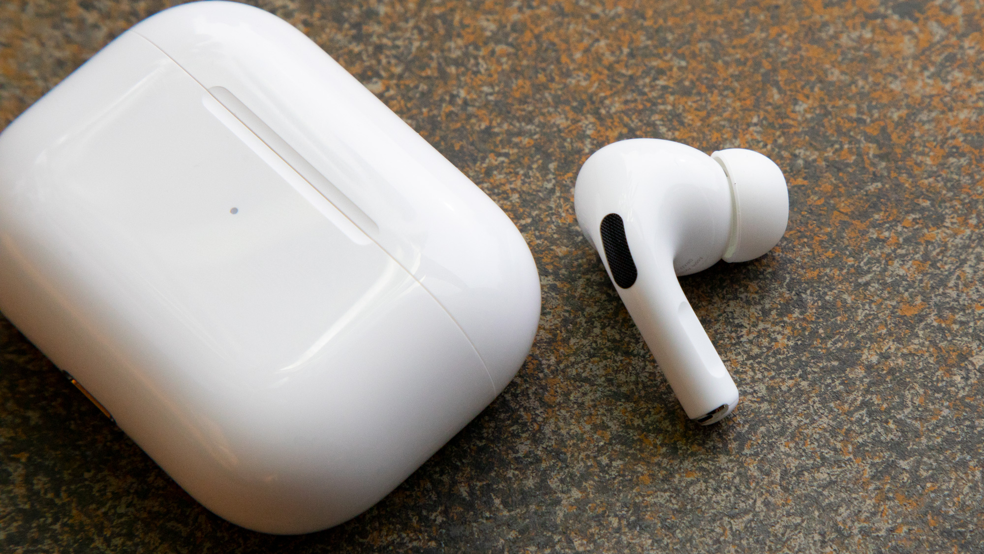 an AirPods Pro earbud next to the charging case
