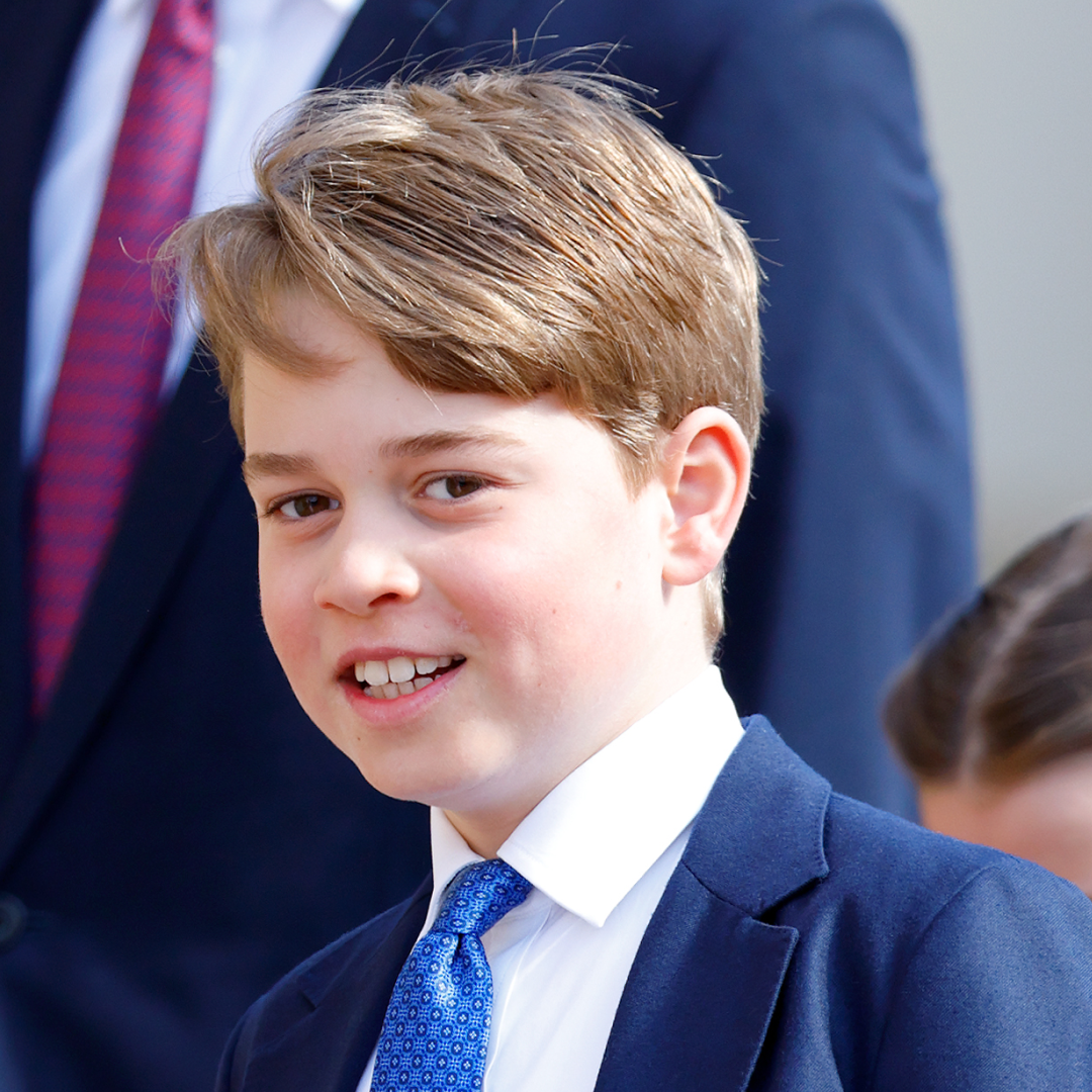 Prince George wears a blue patterned tie with a white shirt and blue suit