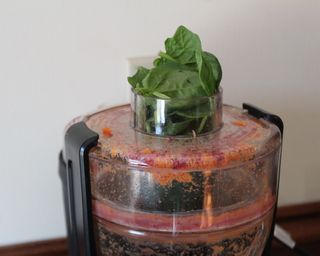 A close-up shot of the Magic Bullet mini juicer with carrot, spinach, carrot and lemon