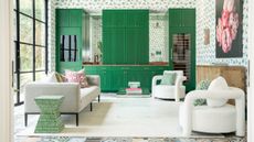 Bright green kitchen cabinets are pictured in the background, behind a white living space with soft sofas and armchairs and a white rug.