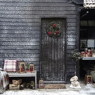 exterior of house with wooden wall and wreath and snow