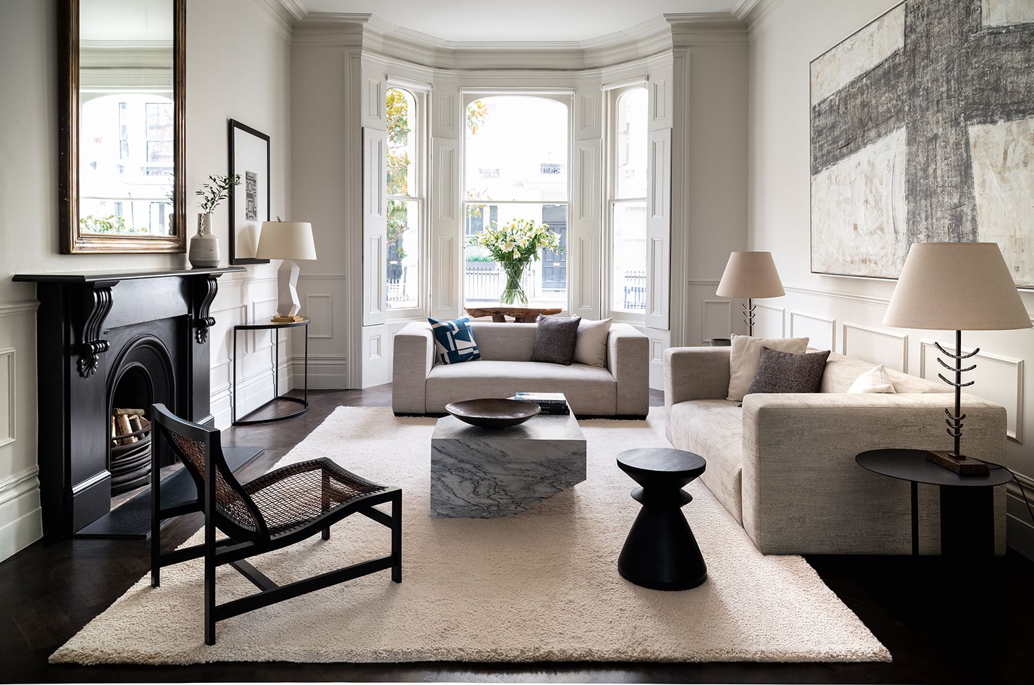 white living room with white sofas and cream rug with a black fireplace