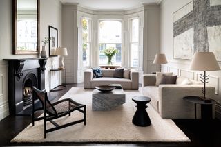 white living room with white sofas and cream rug with a black fireplace