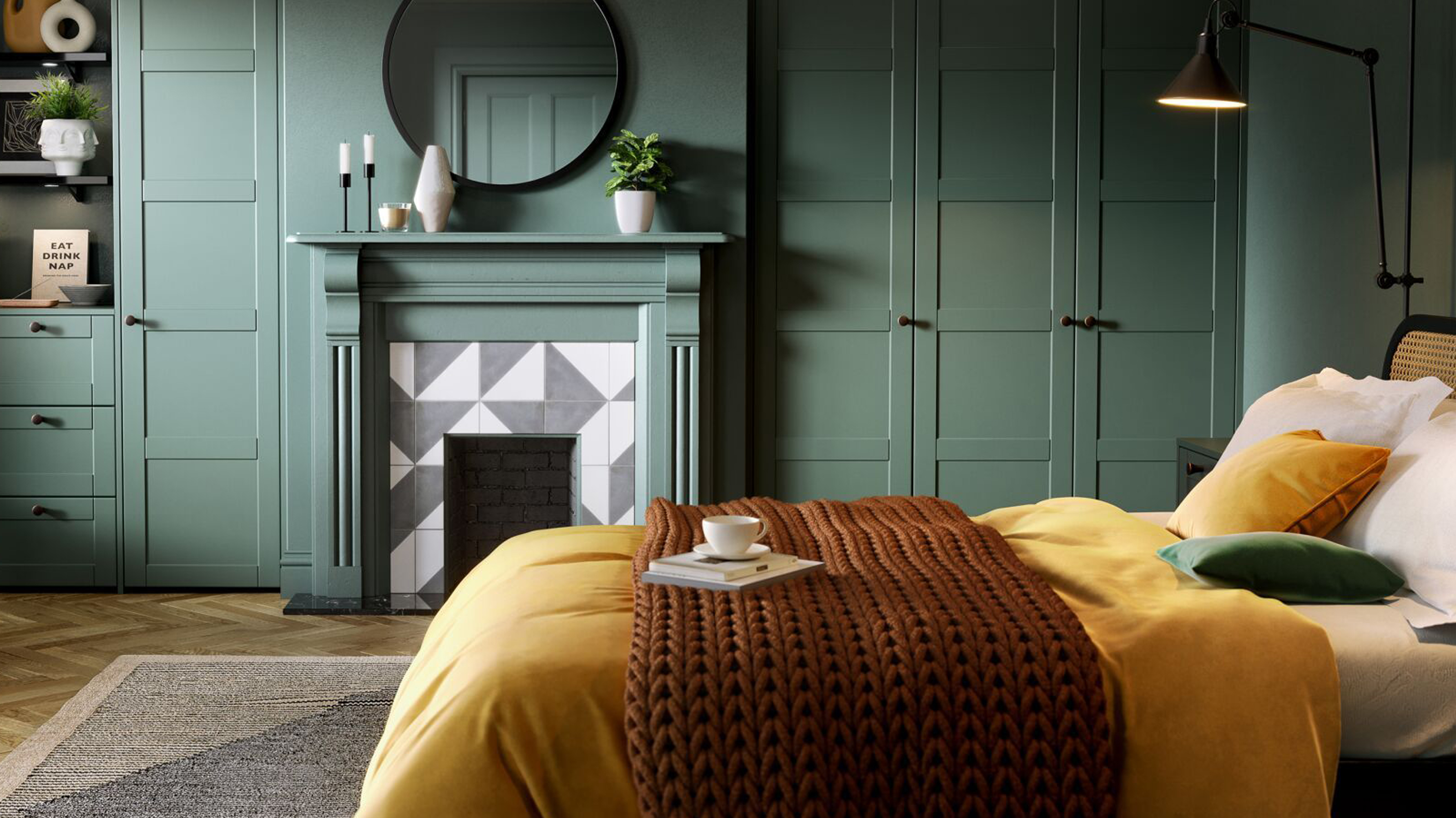 A bedroom with green fitted wardrobes and a fireplace