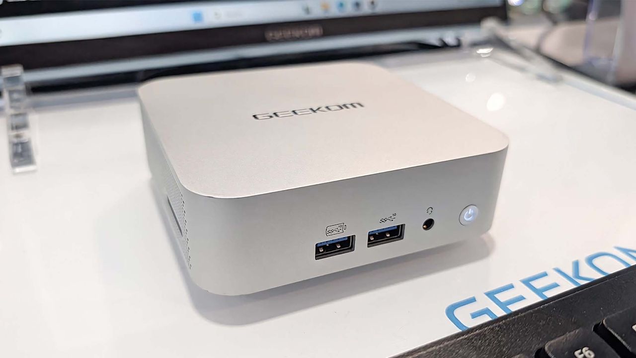 Geekom QS1 mini PC on a table.