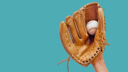 Catching a baseball in a mitt.