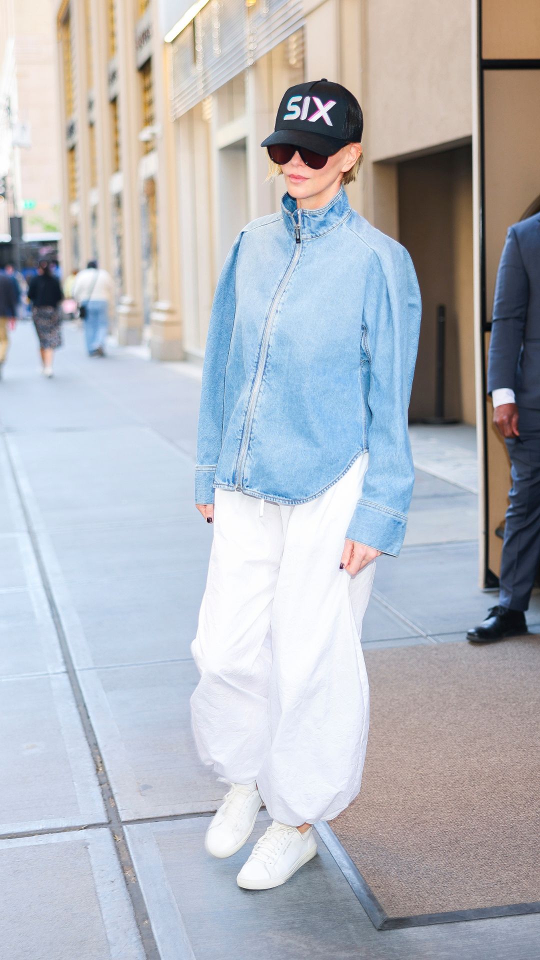 CHARLIZE THERON WEARING A DENIM JACKET AND WHITE TROUSERS