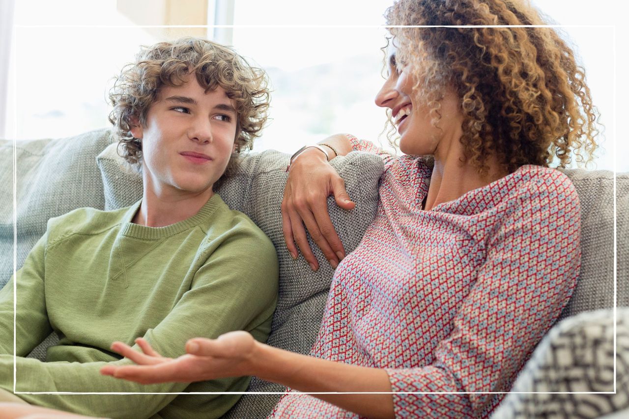 Mother sitting next to teen son on a sofa and smiling