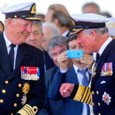 King Harald and King Charles laughing in military uniforms 
