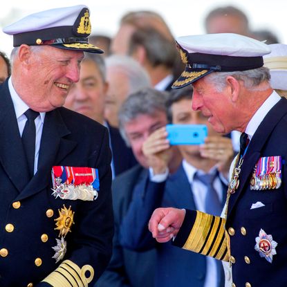 King Harald and King Charles laughing in military uniforms 