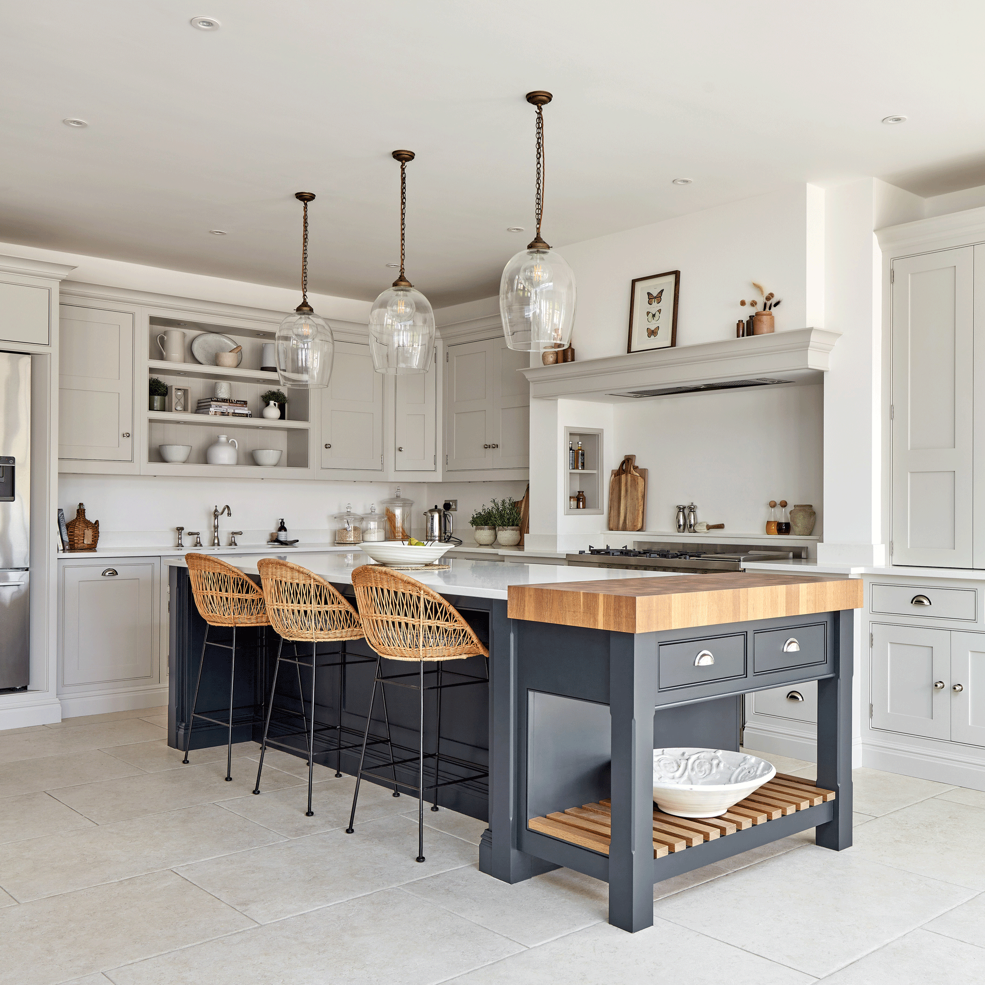 white kitchen with a kitchen island painted navy with a butchers block island at the end