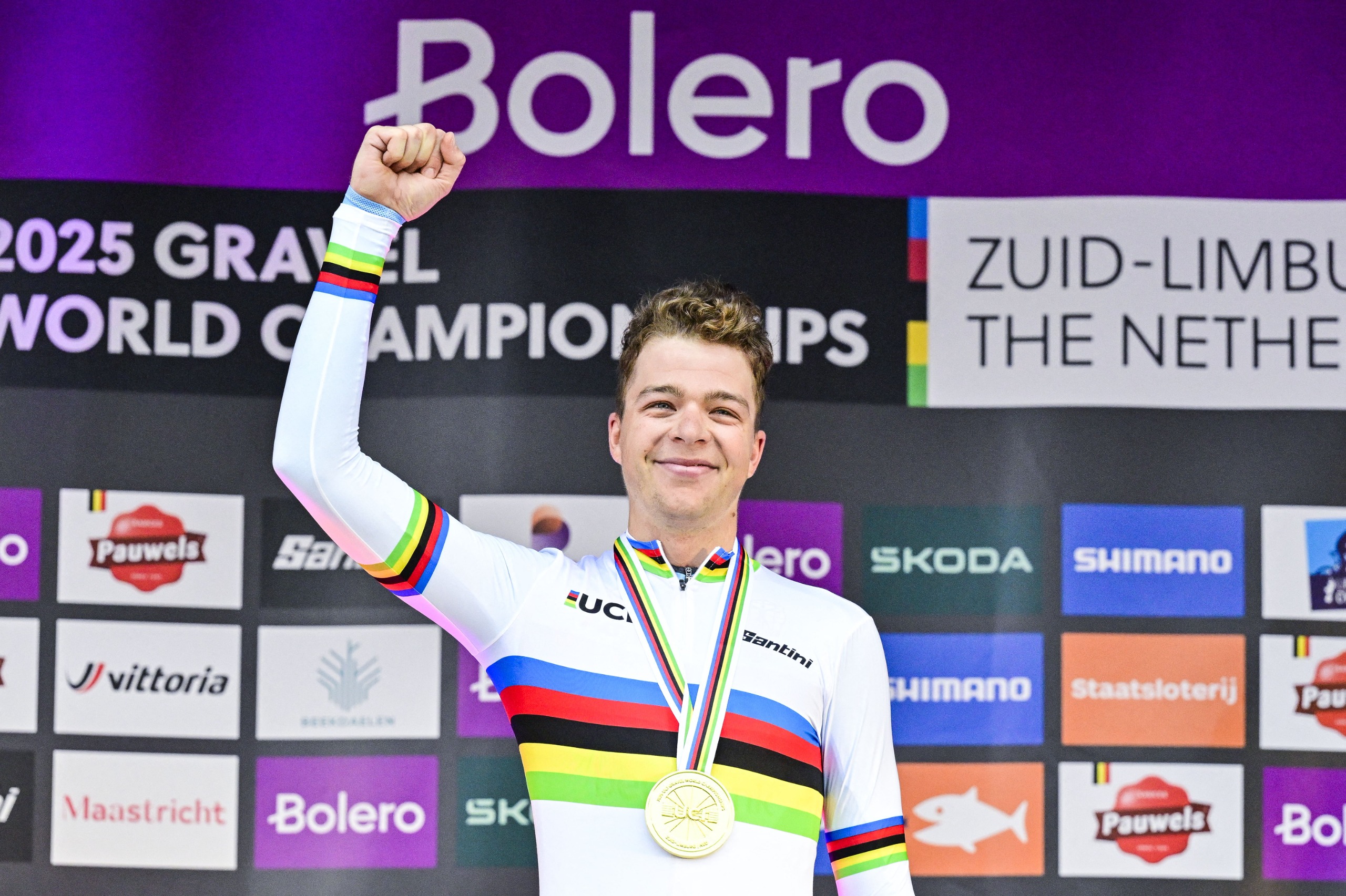 Florian Vermeersch on the top step of the podium in the world champion's jersey at the 2025 UCI Gravel World Championships