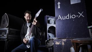 Paul Gilbert plays guitar amid a stack of monitors