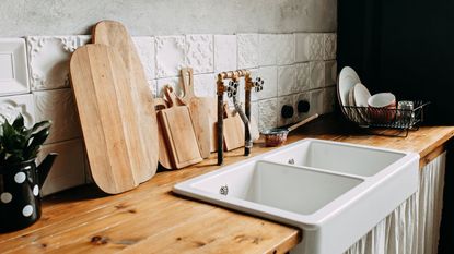 A farmhouse sink with a wooden kitchen counter top