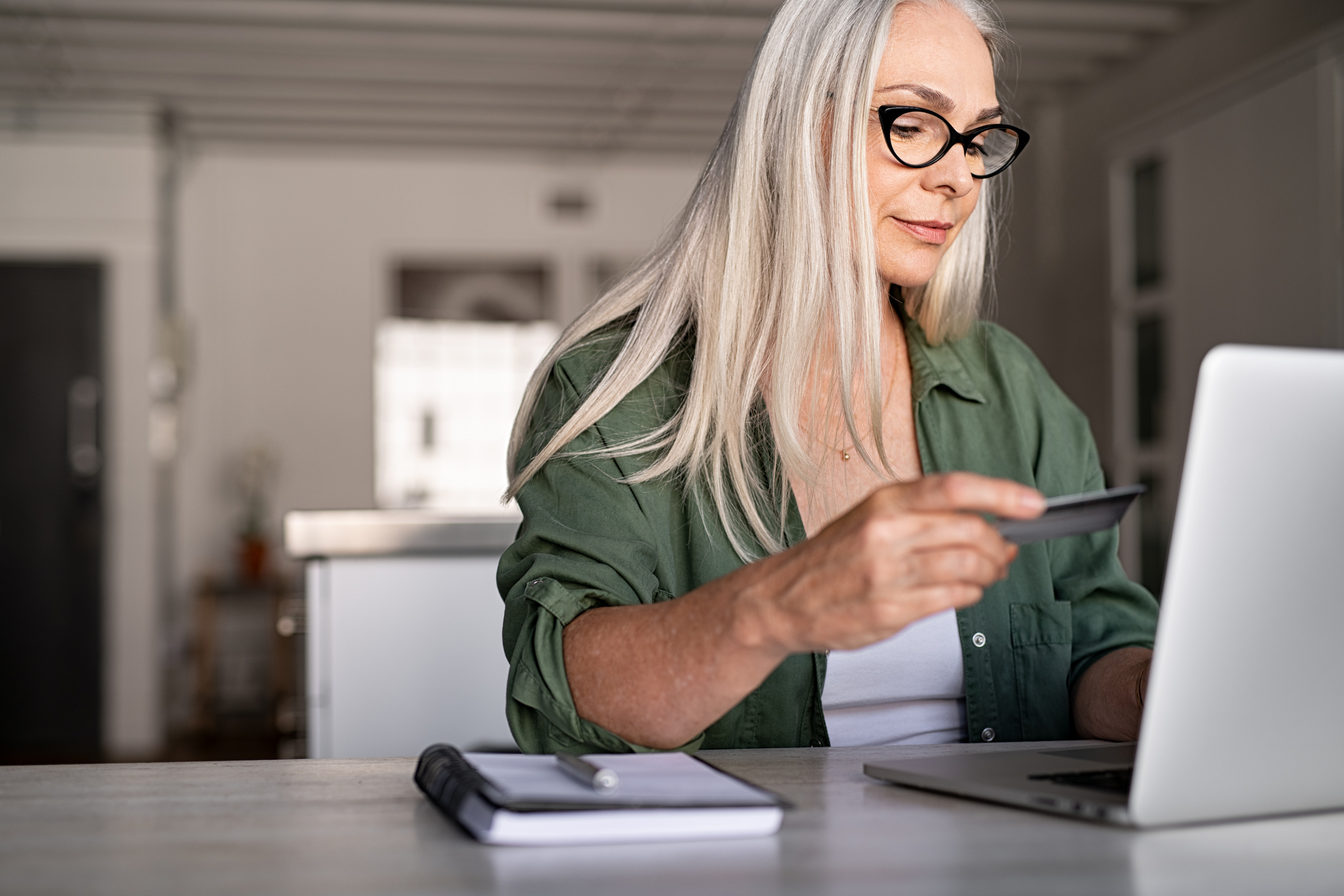 Woman online shopping with credit card in her hand.