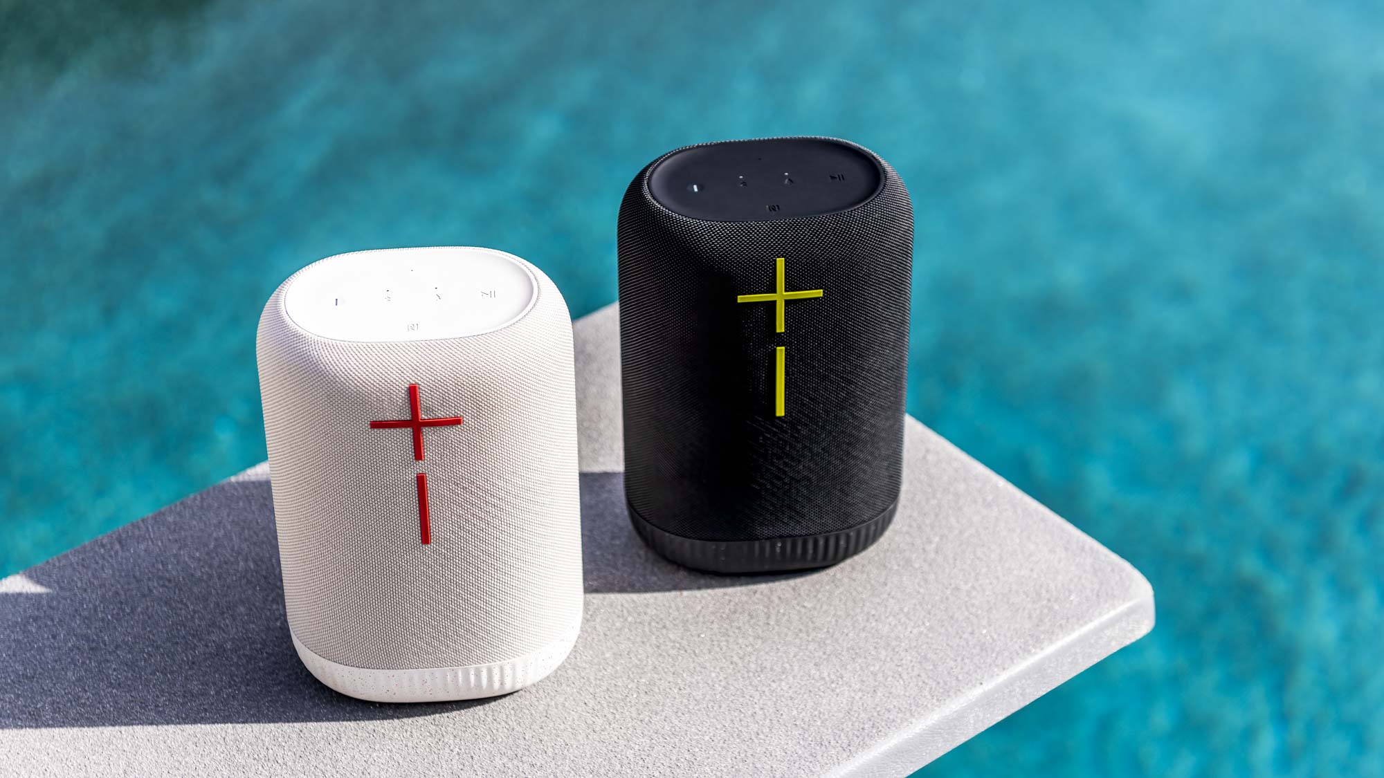 Ultimate Ears Epicboom PR image on showing speakers in black and white versions by a pool