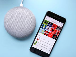 A Google Home Mini next to a Pixel phone with the Podcasts app displayed