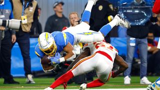Rashad Fenton #27 of the Kansas City Chiefs upends Austin Ekeler #30 of the Los Angeles Chargers during the second half of a game at SoFi Stadium on December 16, 2021 in Inglewood, California.