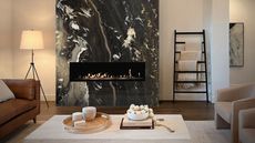 living room with stone fireplace and a towel rail with throws, a floor lamp, tan leather sofa, beige armchairs, and stone coffee table with books and decor