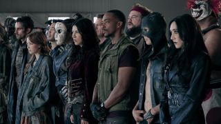 Our destruction derby racers somberly assemble ahead of the deadly tournament, with John Doe (Anthony Mackie) in the middle of the group, flanked by the masked Dollface and his accomplice Quiet (Stephanie Beatrice) to his left, and Raven and crazed clown Sweet Tooth on the far right.