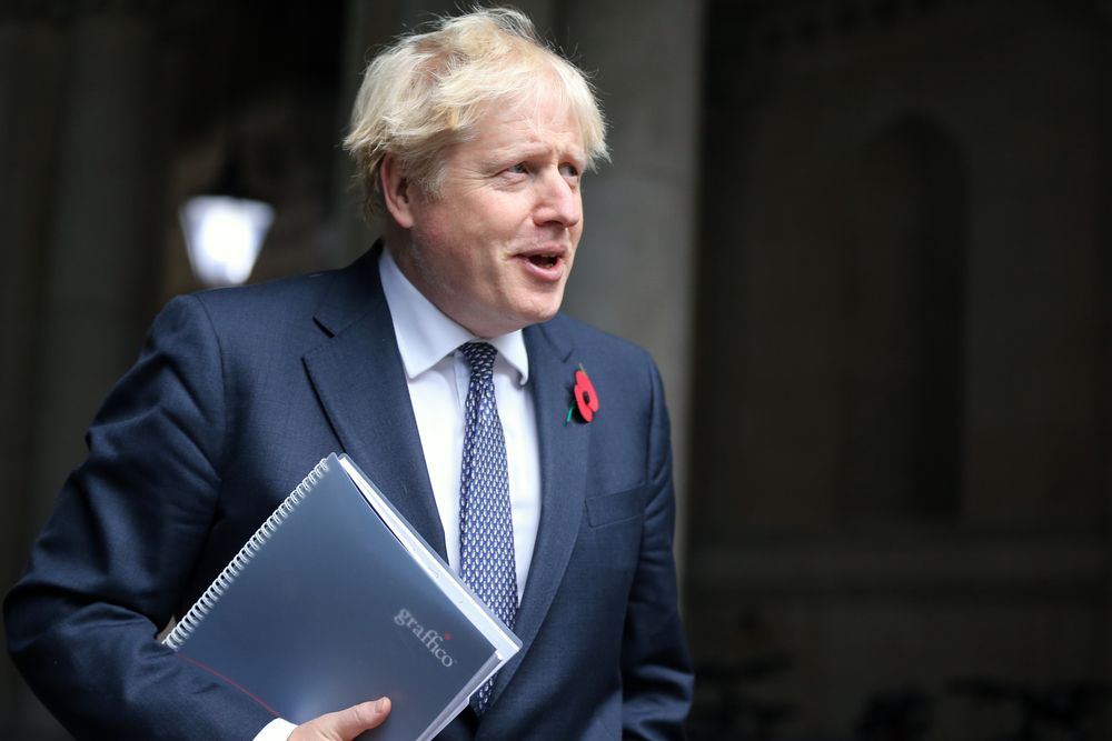 The prime minister, Boris Johnson, holding a folder