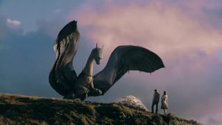 The dragon stands before humans on a cliff with its wings spread in Eragon.