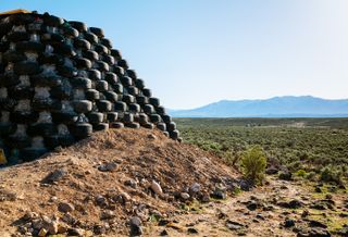 Earthship community in Taos showing colourful off grid homes nestled into the desert earth