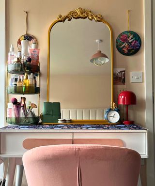 White vanity with gold ornate flower crown mirror, red mushroom lamp and green fluted three tier organizer