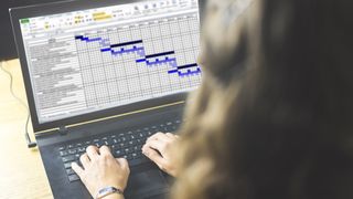 Woman working on laptop with excel spreadsheet open