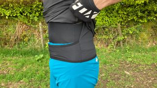 A man lifting a cycling jersey to show an integrated waist band