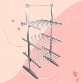 Upright heated clothes airer against pink background