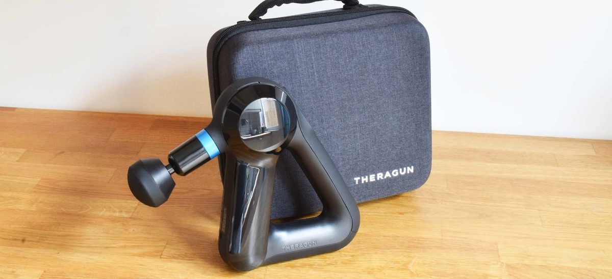 Theragun Elite massage gun next to carry case