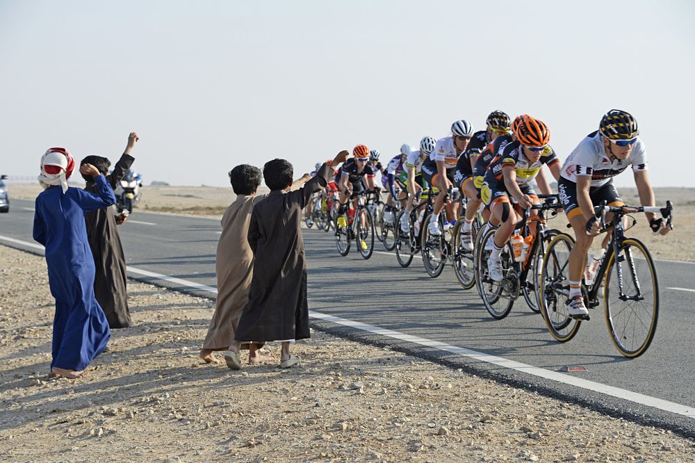 Fans wave at the peloton at the Ladies Tour of Qatar