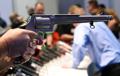 A shooting convention attendee holds a handgun