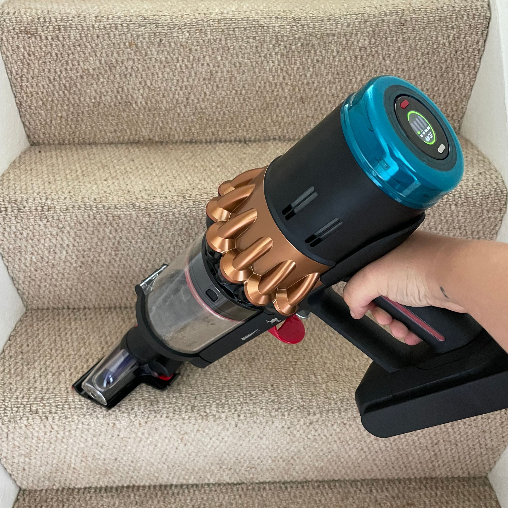 Dyson V16 Piston Animal in handheld form vacuuming wool carpeted stairs