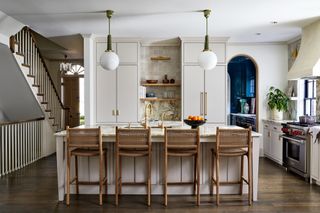 kitchen with off-white cabinets and walls, white island and wooden stools