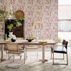 Pink wallpaper, dining table with mid-century style chairs