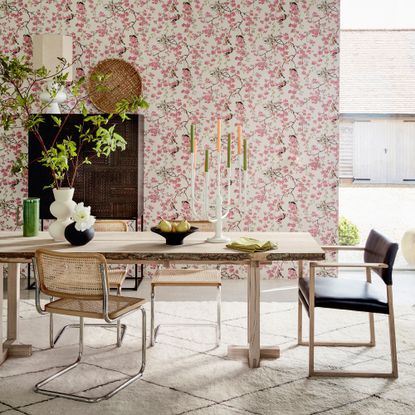 Pink wallpaper, dining table with mid-century style chairs