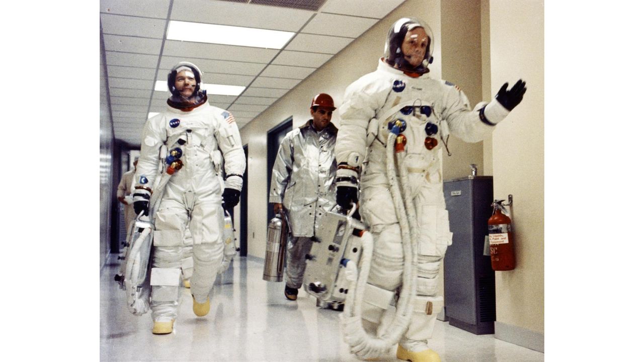 Apollo 11 commander Neil Armstrong (right) waves on the way to launch with fellow crew member Michael Collins (left).