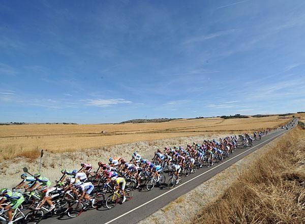The peloton passes through a dry, hot countryside.