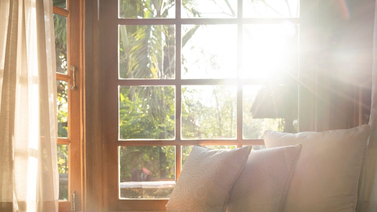 Sun coming through a window and falling on a pile of cushions