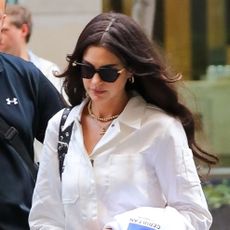 Anne Hathaway wearing a white jumpsuit and flats in NYC