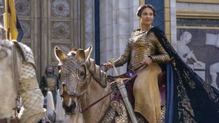 Dronning Miriel smiler, mens hun sidder på en hest i centrum af Numenor i en scene fra serien Magtringene