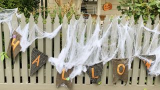 Fence decorated with Halloween bunting and spiderwebs