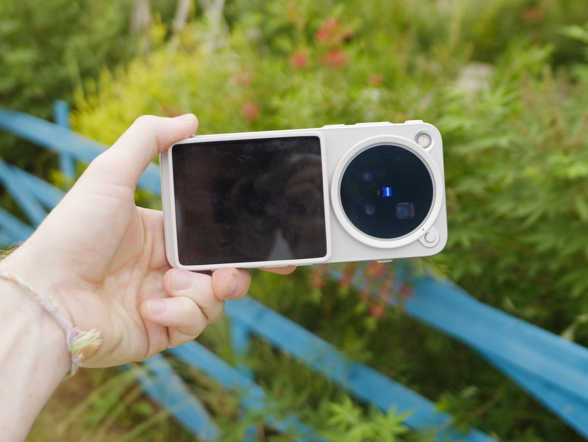 The Vivo X500 Pro Max phone in user's hand, in its dedicated case for magnetic accessories, with Vivo's selfie screen attached